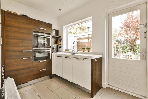 a modern kitchen with wood cabinets and white countertops on the wall, in an open plan space for cooking