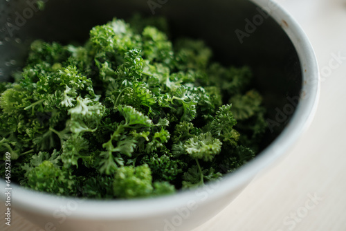 A close-up of a mound of parsley in a metal bowl.
