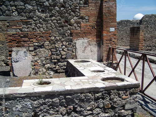 Counter in a shop with holes for barrels of grain in Pompeii, Italy photo