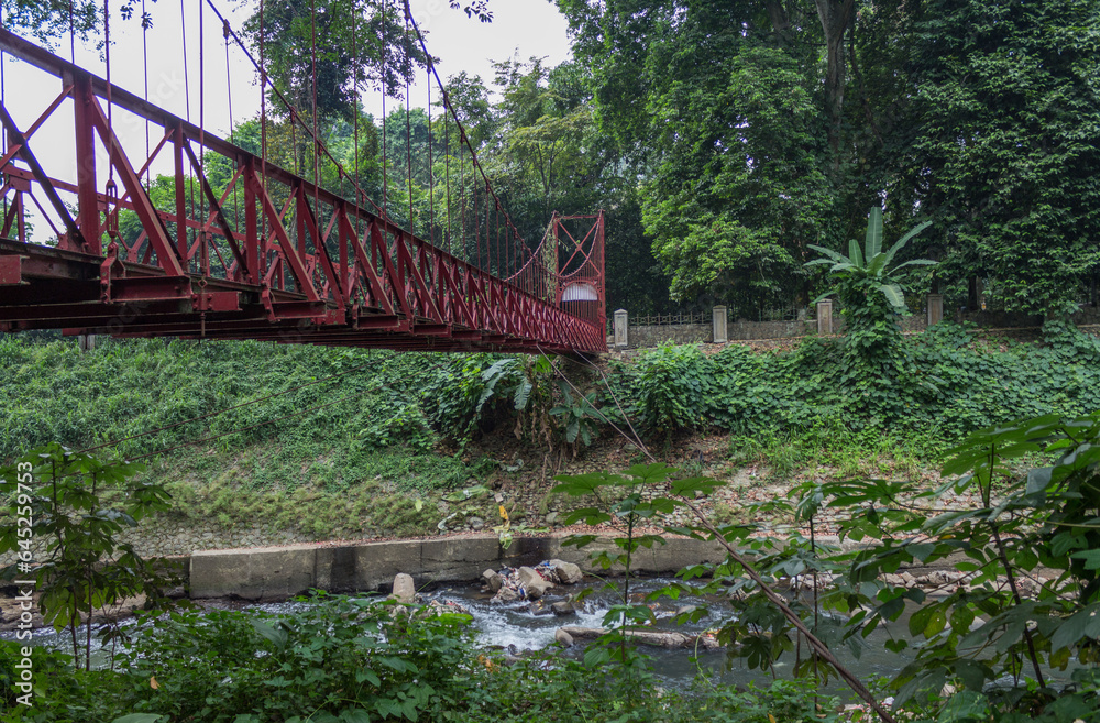 Side view of red bridge over polluted river in Sumatra Indonesia