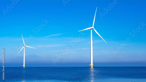 Windmill park with clouds and a blue sky, windmill park in the ocean aerial view with wind turbine Flevoland Netherlands Ijsselmeer. Green energy production in the Netherlands