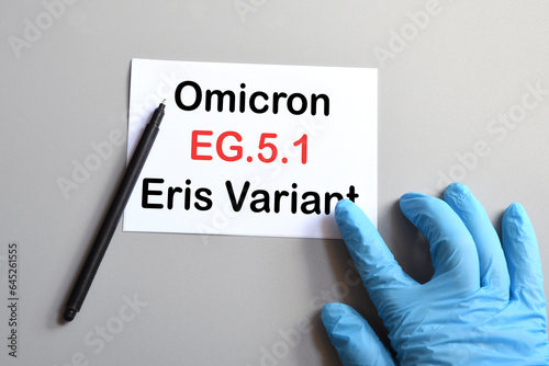 The hands of doctor in blue gloves with white paper and text "Omicron ERIS EG.5.1". Concept for the new variant of SARS-CoV-2 ERIS EG.5.1 Covid-19 New Variants.