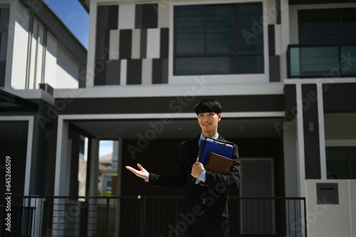 Wallpaper Mural Professional realtor or real estate agent standing in front of house for sale ready to presenting offer Torontodigital.ca