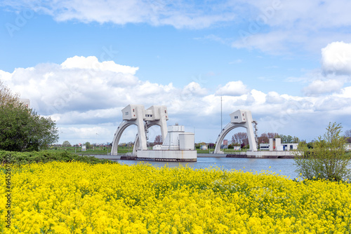 The Stuwcomplex Hagestein  (barrage) in the river De Lek with beautiful yellow rapeseed fields in the foreground