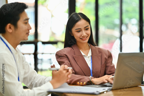 Attractive businesswoman using laptop during corporate meeting. Business and technology concept