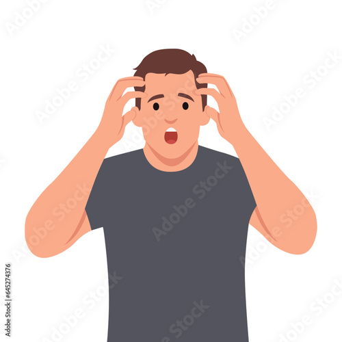 Shocked or amazed young business man holding hands on head and keeping mouth open. Headache pain or stress.