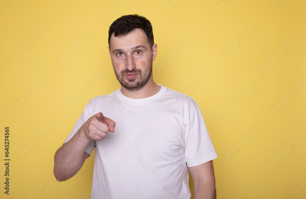 Hey, You. I Choose You. I Pick You. Portrait of excited young man pointing index fingers at camera, posing isolated over yellow studio background. 