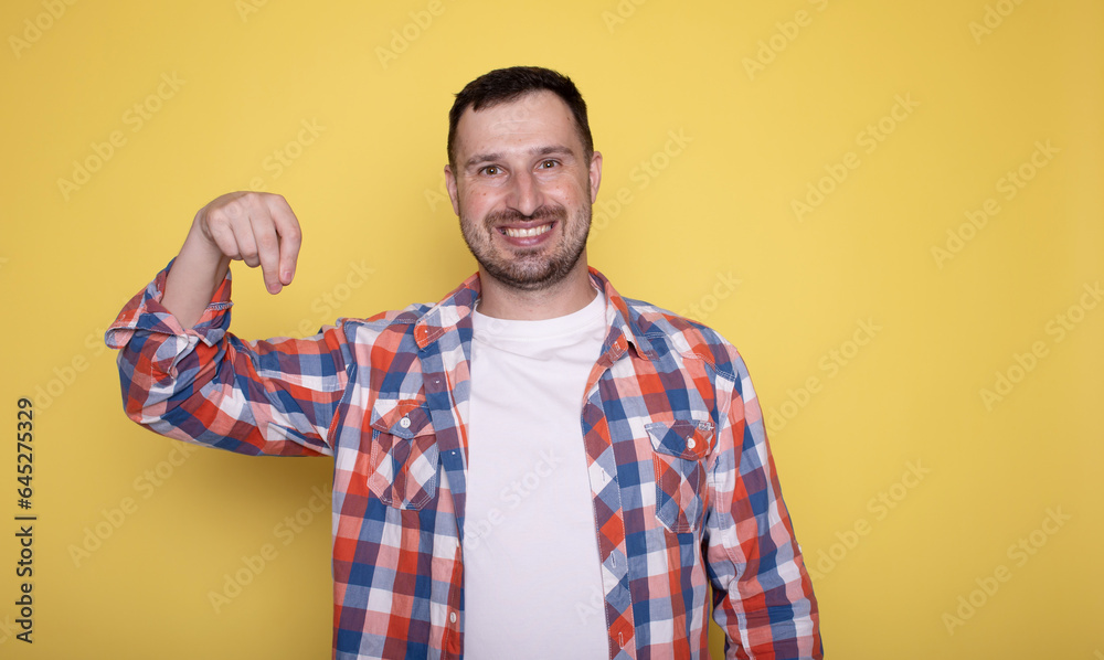 Portrait of excited young man holding something invisible in hand. Positive male showing empty mockup place for ad, banner. Portrait of excited young man holding something invisible in hand. Positive male showing empty mockup place for ad, banner.