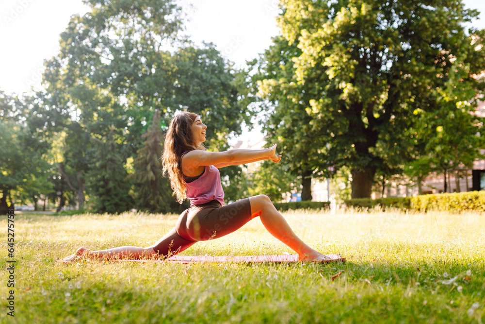 Fitness woman doing yoga, sports exercises in the park. Athletic woman sitting on a mat outdoors on a sunny lawn. Fitness. Active lifestyle. Fitness woman doing yoga, sports exercises in the park. Athletic woman sitting on a mat outdoors on a sunny lawn. Fitness. Active lifestyle.