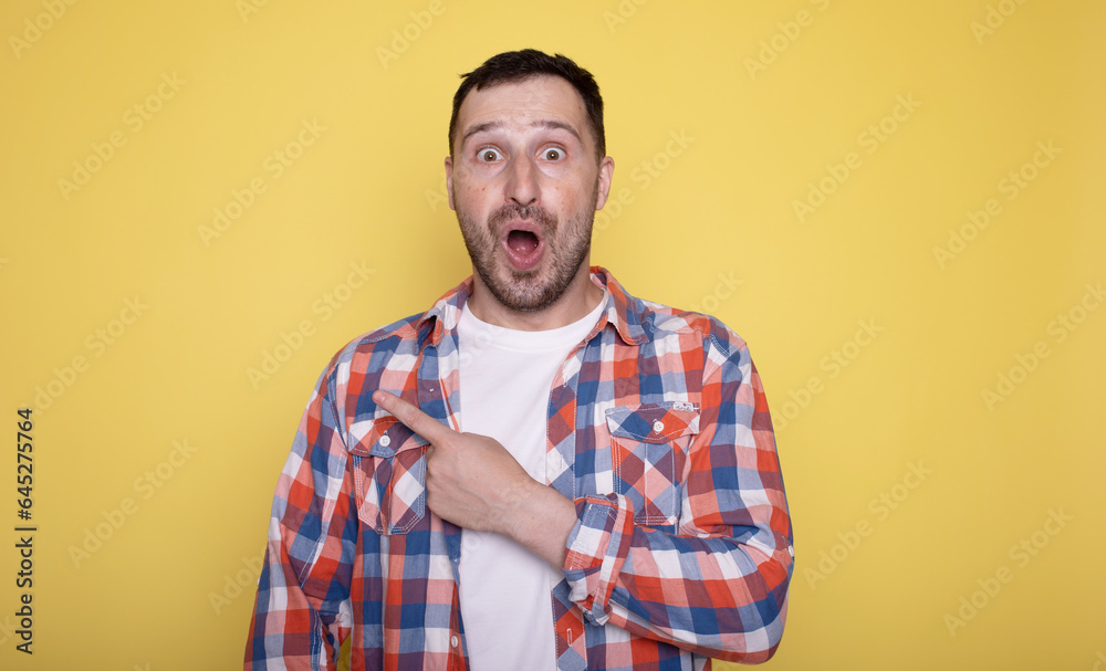 Photo of handsome happy man indicating empty space isolated on yellow background. Photo of handsome happy man indicating empty space isolated on yellow background.
