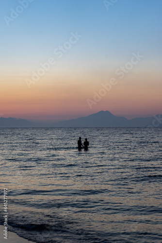zwei silhouetten im Meer bei Sonnenuntergang 