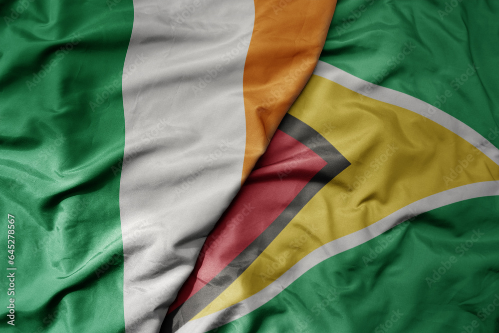 Fototapeta premium big waving national colorful flag of ireland and national flag of guyana .