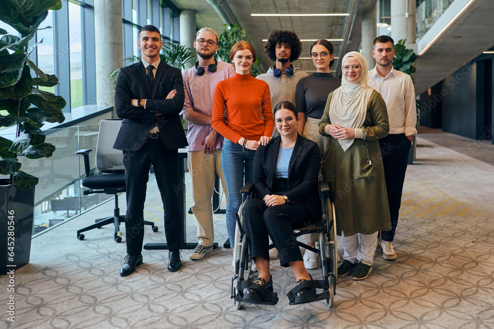 Fototapeta premium In a spacious and modern startup office, a diverse group of business colleagues, including a colleague in a wheelchair, collaborates and interacts, exemplifying inclusivity, diversity, and teamwork in