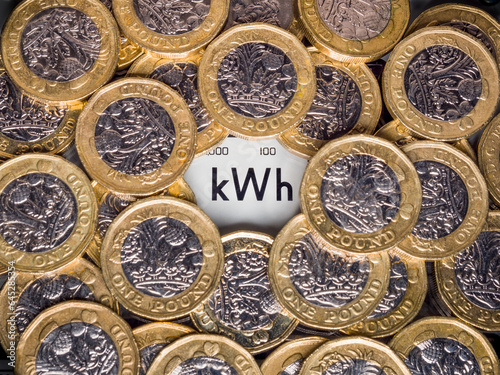Electricity meter kWh symbol surrounded with one pound coins. Concept for energy supplier, high bills, price rise, cost of living, inflation and expensive fuel.