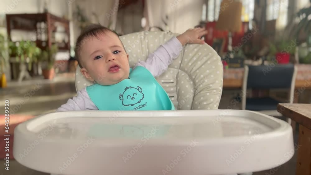 Hungry baby ready for a meal, zoom out of Caucasian toddler sitting in a high chair Hungry baby ready for a meal, zoom out of Caucasian toddler sitting in a high chair