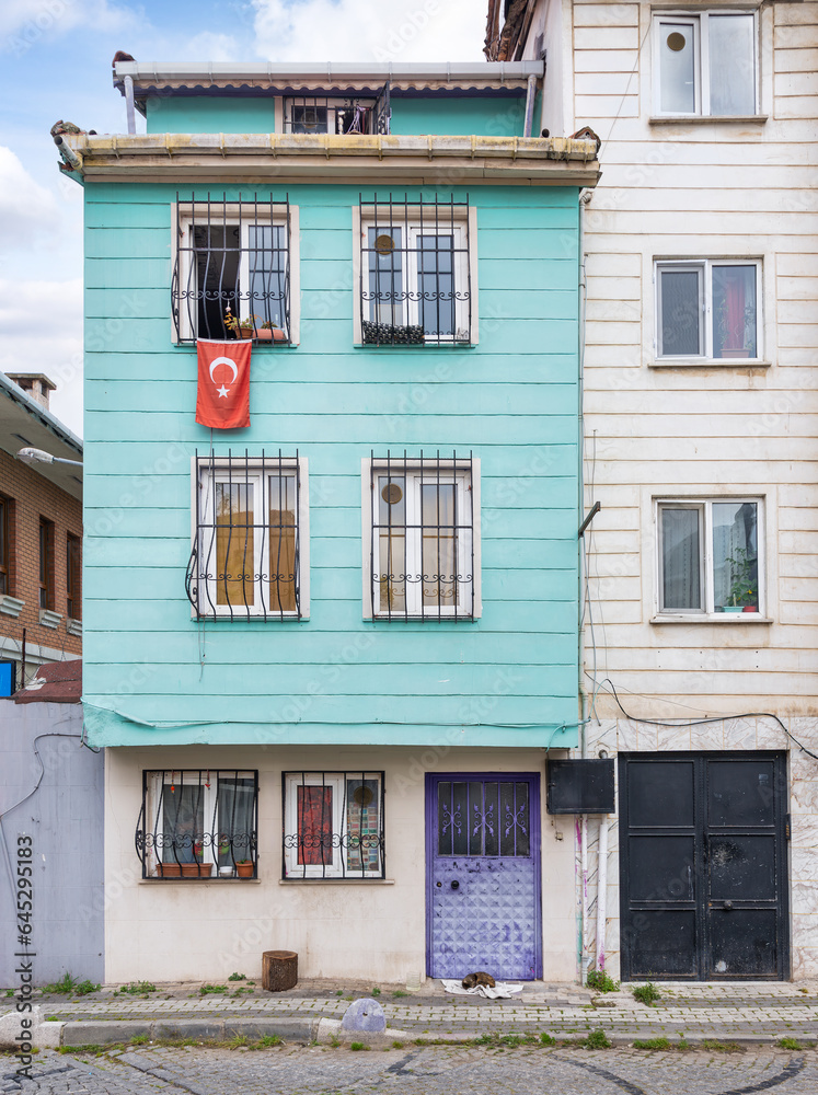 Wooden traditional residential building with a Turkish flag hanging from its window, located in Uskudar, a district of Istanbul, Turkey
