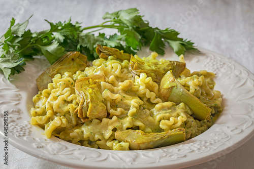 A dish with pasta with artichokes and parsley. photo