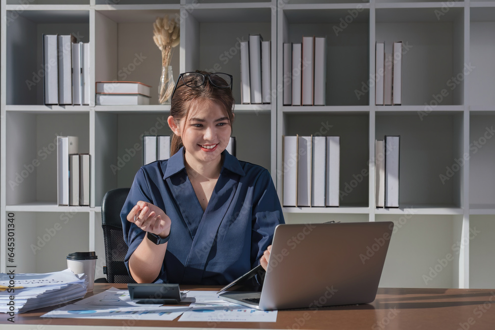 Young accountant uses a calculator to calculate taxes and manage business accounts in the office. Young accountant uses a calculator to calculate taxes and manage business accounts in the office.