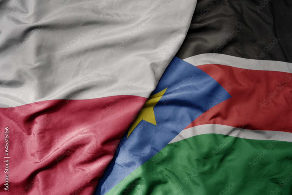 Fototapeta premium big waving national colorful flag of poland and national flag of south sudan .