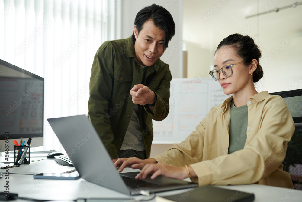 Team leader supporting junior developer working on her first project for company Team leader supporting junior developer working on her first project for company