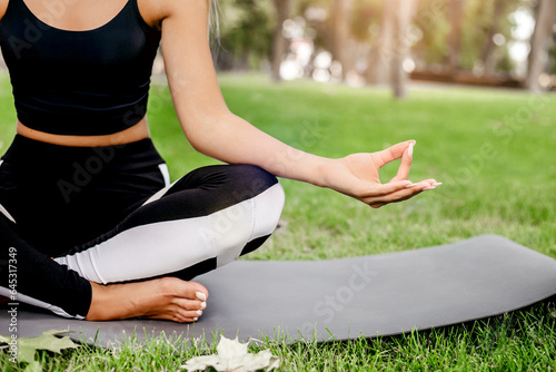 girl doing yoga and meditating in the park