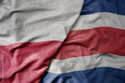 big waving national colorful flag of poland and national flag of costa rica . © luzitanija