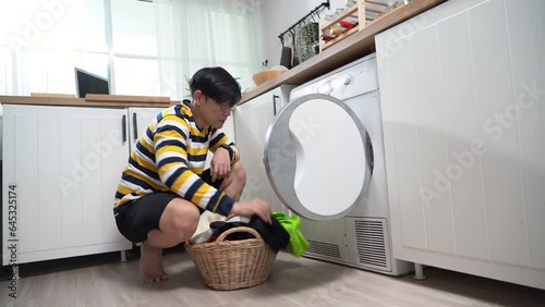 asian man washing clothes at laundry room photo