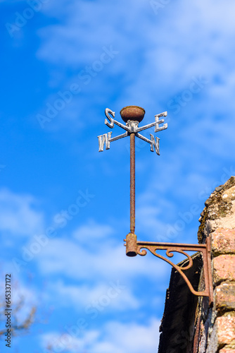 Old weathervane on the side of a barn, missing the cockrel.