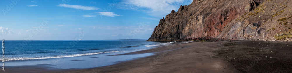 Panoramic view of Las Gaviotas playa, Canary Islands beach with black volcanic sand located at the foot of a cliff Panoramic view of Las Gaviotas playa, Canary Islands beach with black volcanic sand located at the foot of a cliff