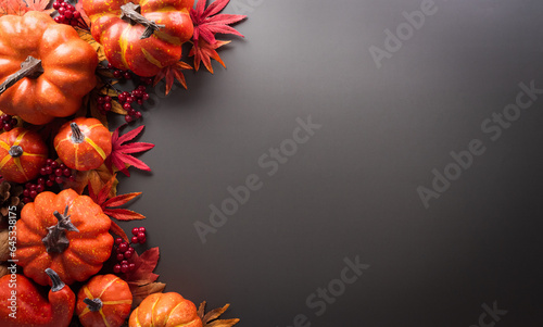 Thanksgiving and Autumn decoration concept made from autumn leaves and pumpkin on dark background. Flat lay  top view with copy space.