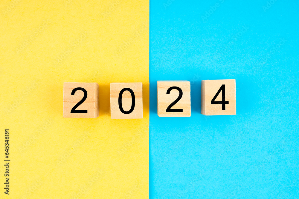 The Number 2024 on wooden cube blocks with yellow and blue background. The Number 2024 on wooden cube blocks with yellow and blue background.