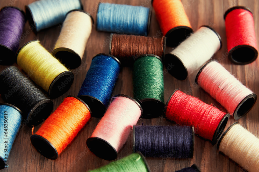 Scattered spools of thread on a seamstress's wooden table. Embroidery theme. Scattered spools of thread on a seamstress's wooden table. Embroidery theme.