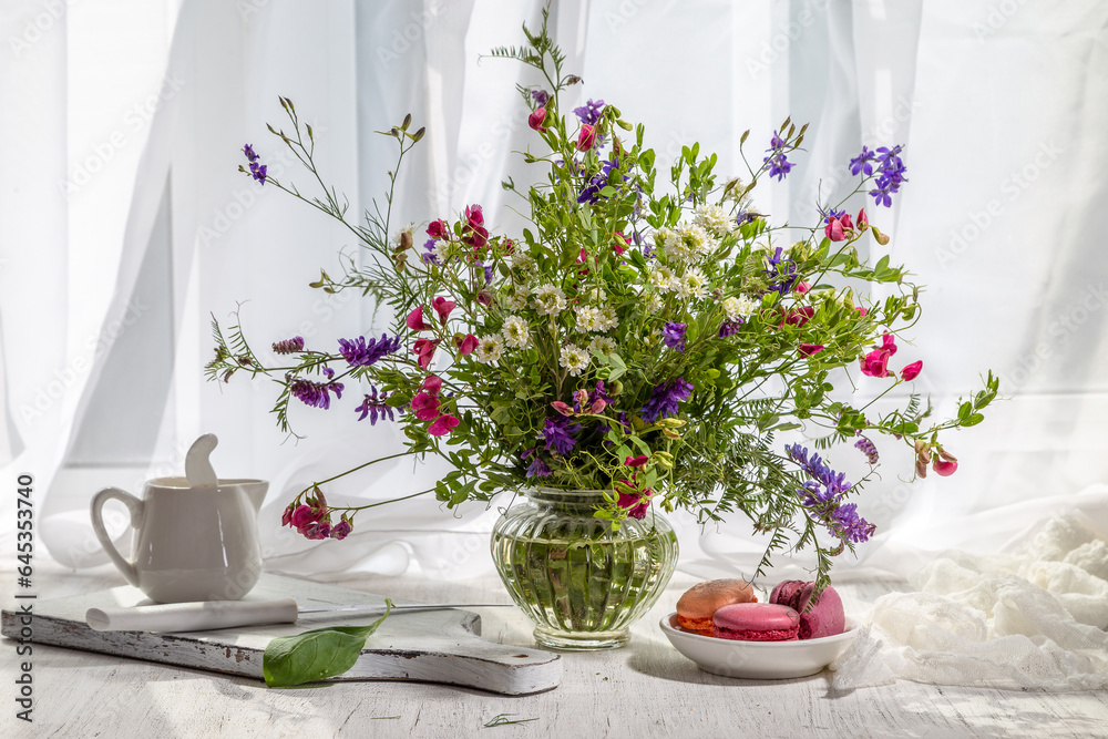 Still life with a bouquet of wild flowers on the windowsill on a sunny day