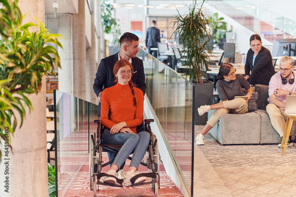 A company director assists his business colleague in a wheelchair, helping her navigate to their startup office, where they work alongside their diverse team of colleagues, emphasizing inclusivity and