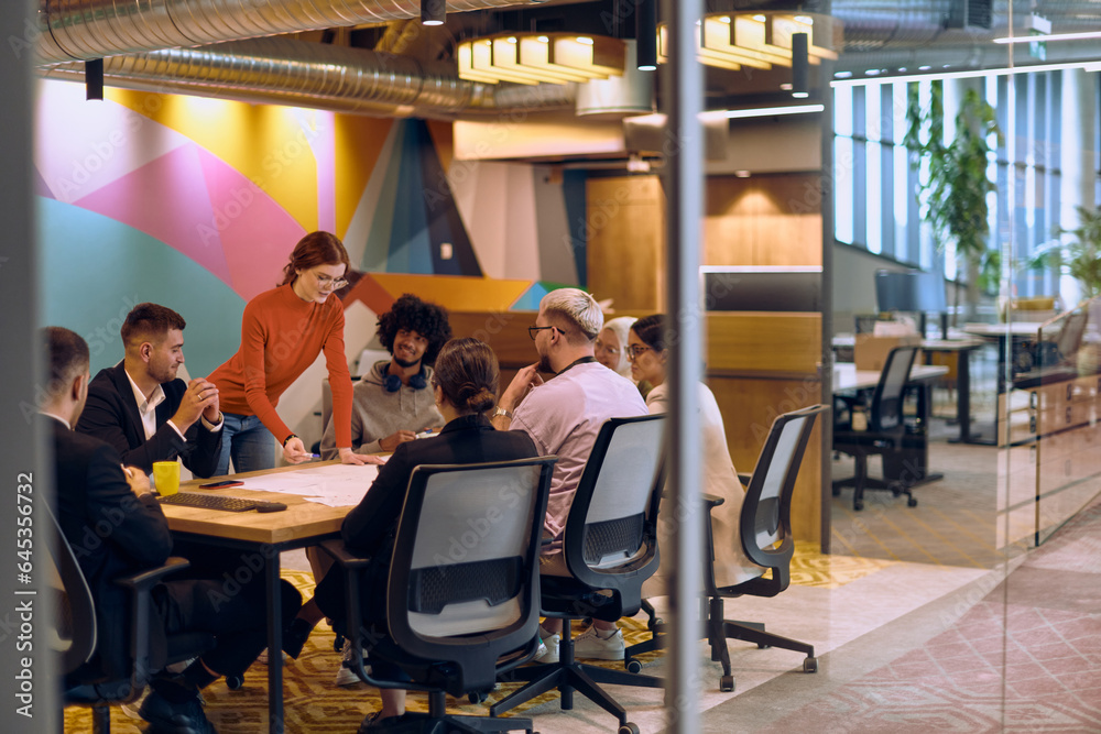 A diverse team of business experts in a modern glass office, attentively listening to a colleague's presentation, fostering collaboration and innovation. A diverse team of business experts in a modern glass office, attentively listening to a colleague's presentation, fostering collaboration and innovation.