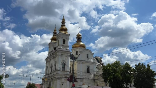 Golden domes in the church against the background of the blue sky, white walls of the cathedral in the city of Vinnitsa on Central Square, Sobornaya street, Ukraine photo