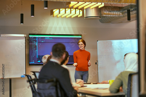 A pregnant business woman with orange hair confidently presents her business plan to colleagues in a modern glass office, embodying entrepreneurship and innovation