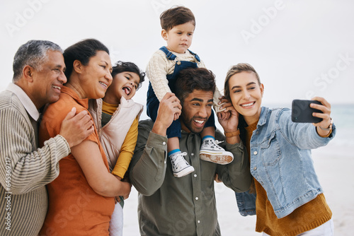 Happy family, grandparents and selfie on beach for kids holiday, vacation and outdoor on social media. Mother, father and senior people with interracial children in profile picture by the ocean © Wesley/peopleimages.com