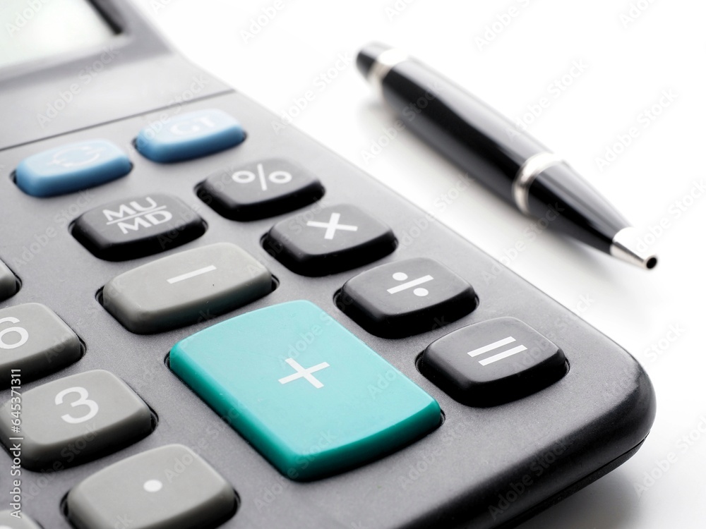 Close up of a black calculator and pen. Side view Close up of a black calculator and pen. Side view