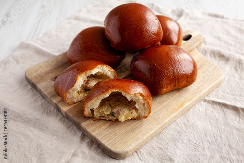 Homemade Pirozhki with Potato and Bacon on a wooden board, side view. photo