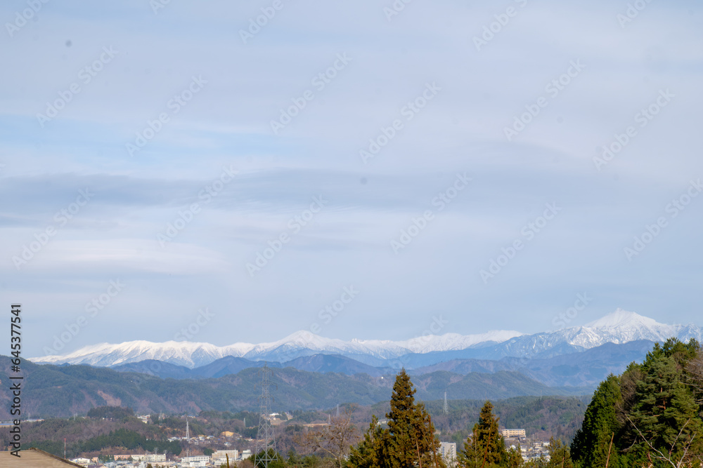 the awe-inspiring beauty of the Japanese Alps as seen from the charming town of Takayama