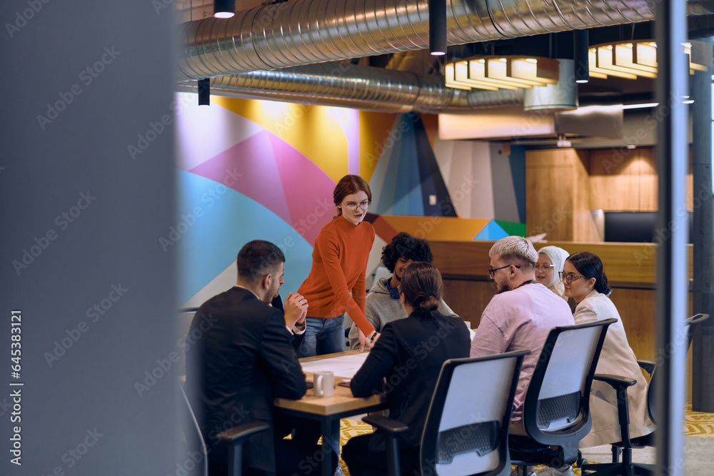 A diverse team of business experts in a modern glass office, attentively listening to a colleague's presentation, fostering collaboration and innovation. A diverse team of business experts in a modern glass office, attentively listening to a colleague's presentation, fostering collaboration and innovation.