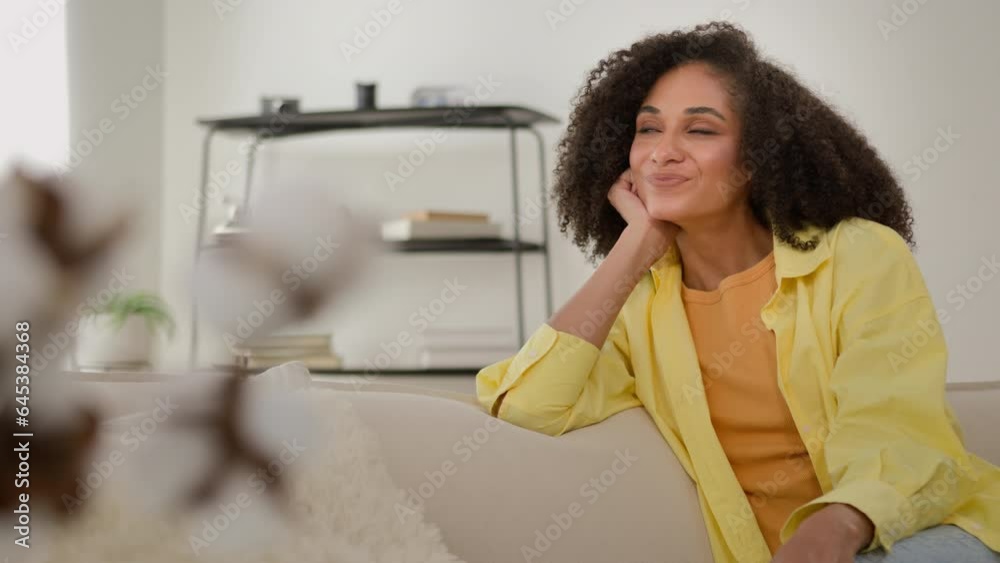 Dreamy African American ethnic calm woman dreaming on couch cozy sofa leisure relaxed girl home owner enjoy comfort fresh air rest at own rented apartment thinking smiling imagine future plans dreams Dreamy African American ethnic calm woman dreaming on couch cozy sofa leisure relaxed girl home owner enjoy comfort fresh air rest at own rented apartment thinking smiling imagine future plans dreams