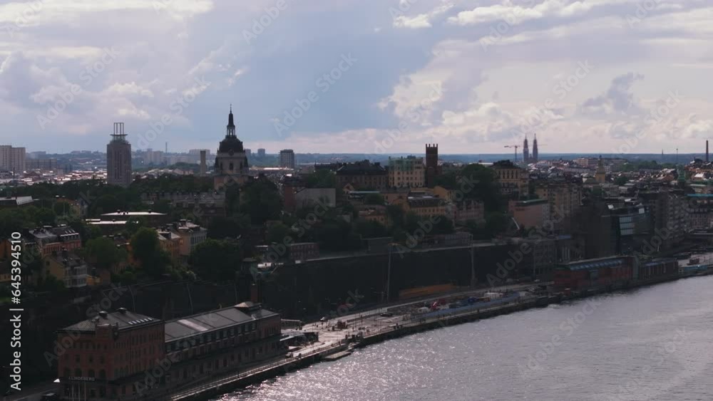 Fly above water in city. Elevated view of tourist sight on waterfront. Fotografiska museum and Katarina Church against sunshine. Stockholm, Sweden Fly above water in city. Elevated view of tourist sight on waterfront. Fotografiska museum and Katarina Church against sunshine. Stockholm, Sweden