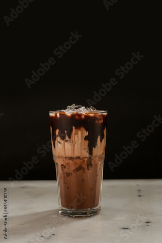 Iced chocolate, dark, cocoa, brown, milk mixed drinks. Menu for restaurant, cafe, ice, glass on black background.