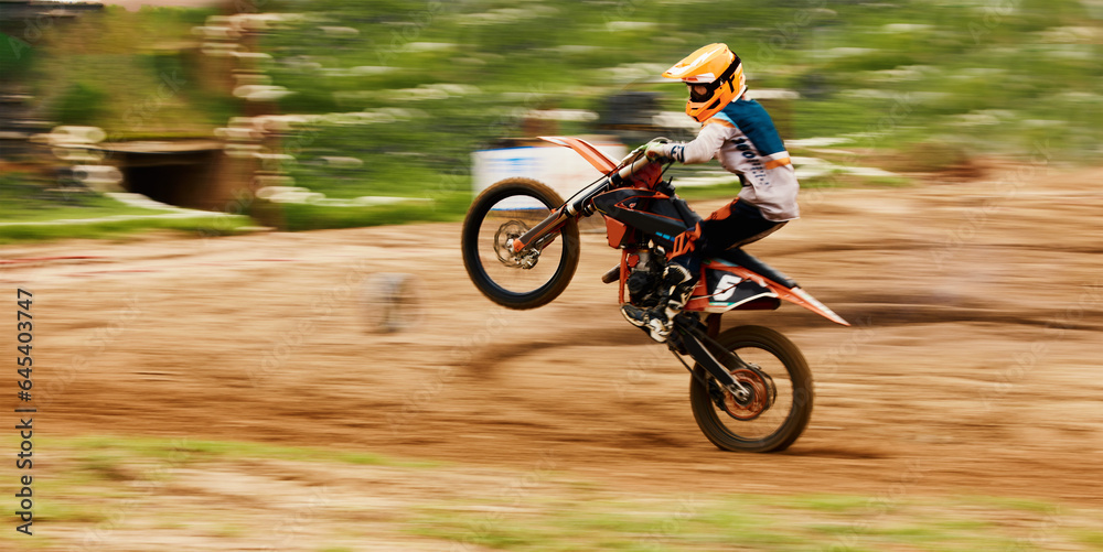 Motorcycle, balance and motion blur with a man at a race on space in the forest for dirt biking. Bike, fitness and power with a sports person driving fast on an off road course for freedom or speed