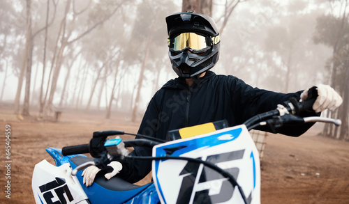 Motorcycle, person and sport in forest with training for competition, ride in nature with action and helmet. Extreme, adrenaline and exercise, athlete and transport with dirt bike, freedom and travel © Anela/peopleimages.com