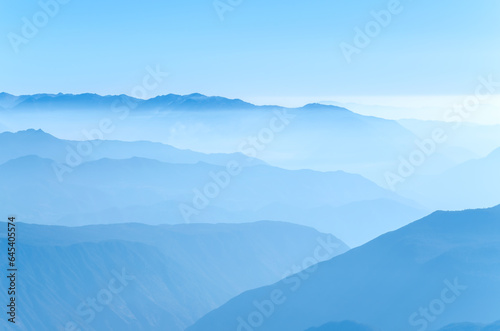 Mountains with cloud and fog in morning. Blue color mountain abstract background.