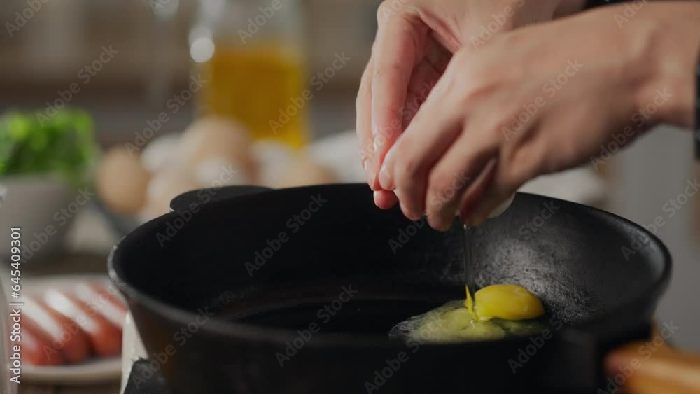 Fry. Happy young parent girl in a kitchen apron breaks an egg into a frying pan in the kitchen. Camera movement modern girl beats egg shells on a frying pan maintaining a balanced diet, bread Fry. Happy young parent girl in a kitchen apron breaks an egg into a frying pan in the kitchen. Camera movement modern girl beats egg shells on a frying pan maintaining a balanced diet, bread