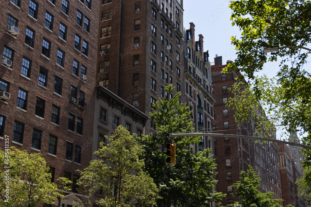 Row of Old Residential Buildings and Skyscrapers along Fifth Avenue in Greenwich Village of New York City Row of Old Residential Buildings and Skyscrapers along Fifth Avenue in Greenwich Village of New York City